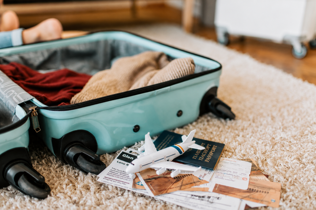 Close-up of an open suitcase with travel essentials like passport and tickets, ready for a journey.